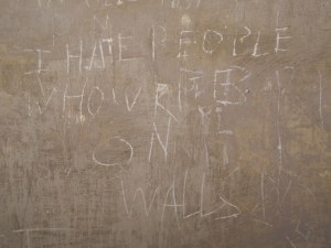 Graffiti located in a cell on Corridor 2 of Floor 3. 'I hate people who graffiti on walls'.