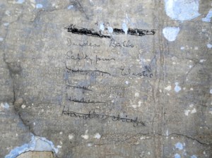 List of provisions (with lines through a number) including 'safety pins' and 'elastic'. Located in a cell on Corridor 1 of the Top Floor.